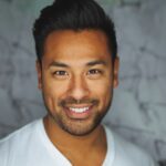 Headshot of a smiling professional man with a short beard in a white T-shirt