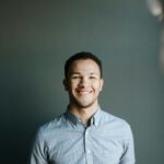 Portrait of a smiling young professional in a light blue button-down shirt